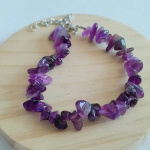Detailed view of natural purple amethyst fragment bracelet on a wooden round stand
