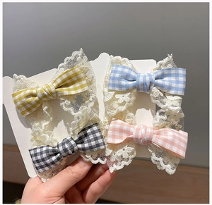 Detail view of 4-piece set of plaid bow hair clips with white lace trim for girls