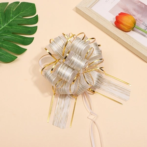 Macro shot of a decorative gold ribbon bow with metallic edges for gift wrapping