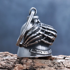 Macro shot of retro silver skull bell pendant with Born to Be Free engraving