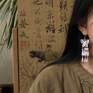 Silver hollow butterfly tassel earrings with vintage ethnic fringe on model