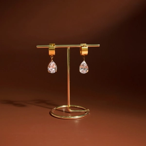 Détail de boucles d'oreilles goutte en zircon sur un support doré minimaliste