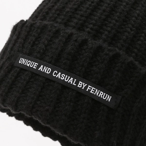 Minimalist black knitted beanie for women featuring unique decorative patch and warm texture