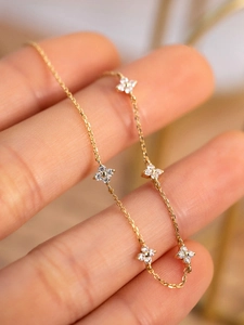 Macro shot of 18K gold plated S925 silver four-leaf clover bracelet with zircon stones