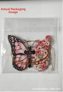 Detail of creative acrylic butterfly cross pendant with pink flowers and gold cord