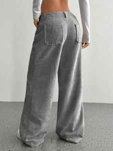 Dettaglio posteriore dei pantaloni in velluto a coste grigio con tasca e drappeggio