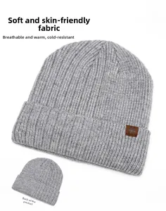 Detail view of grey ribbed knit beanie showing soft texture and snowflake leather patch