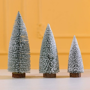 Miniature flocked Christmas trees with wooden bases for festive tabletop decor