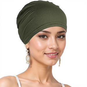 Olive green turban hat for women in soft elastic fabric shown on a smiling model