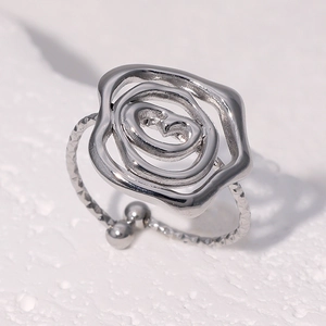 Detail of silver rose-shaped open ring featuring intricate petal design and textured band