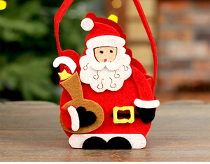 Detail of felt Christmas gift bag featuring Santa Claus on dark wood background