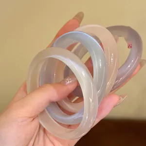 Dettaglio di quattro bracciali in calcedonio traslucido nei colori bianco blu rosa viola