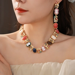 Close-up of vintage gold jewelry set with colorful cameo gems and floral rhinestone detail