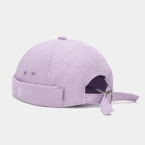 Detail of purple canvas docker hat featuring white N embroidery and adjustable metal buckle