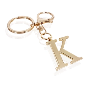 Detail of a golden metal letter K keychain with round ring and lobster clasp closure