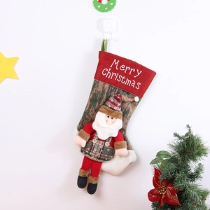 Detail eines Weihnachtsstrumpfs aus Stoff mit 3D-Weihnachtsmann an festlicher Wand