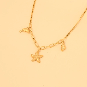 Detail shot of golden starfish, shell, and dolphin charms on a stainless steel necklace