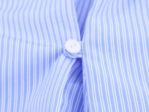 Vista macro dettagliata dei bottoni bianchi sul tessuto della camicia a righe blu