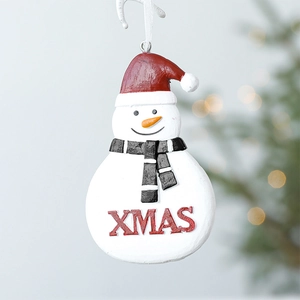 Hanging resin Christmas snowman ornament with XMAS lettering on a festive tree background