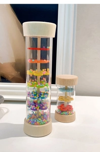 Detailed macro view of wooden rainmaker toy with colorful beads and clear plastic tube