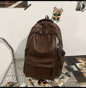 Dettaglio della trama dello zaino in pelle PU marrone scuro e tasca anteriore con zip