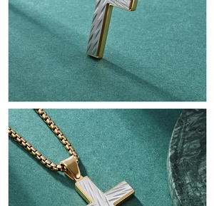 Detailed close-up of a gold T-bar cross pendant necklace with textured silver inlays