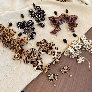 Detail of leopard print fabric flower tassel earrings in multiple colors and vintage patterns