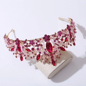 Macro detail of golden bridal crown featuring red gemstones and intricate pink flower beads