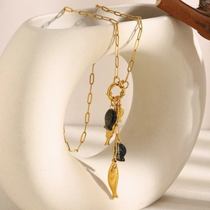 Detailed macro view of 18K gold-plated paperclip chain with black and gold fish charms