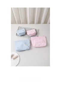 Détail de trousses à maquillage à rayures avec broderie nœud délicate et fermeture éclair