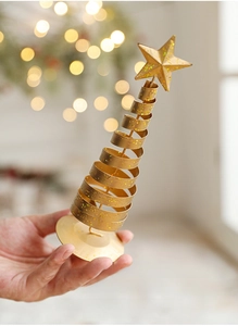 Detail of hand-held gold spiral Christmas tree ornament with a sparkling star topper