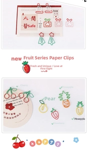 Macro detail of various colorful fruit-shaped paper clips including cherry and strawberry