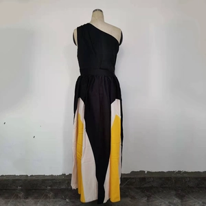 Detail of color-block patchwork and one-shoulder neckline on a flowy summer maxi dress