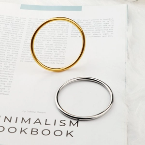 Minimalist 4mm 18k gold and silver stainless steel bangles on a luxury lookbook