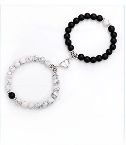 Detail of couple bracelets with white turquoise matte beads and heart magnetic clasp