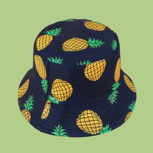 Detail of navy bucket hat featuring yellow pineapple patterns and stitched brim