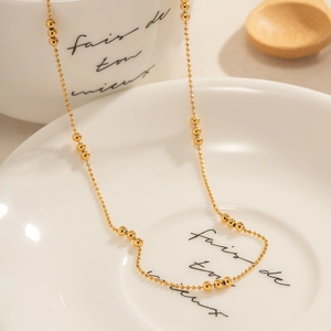 Minimalist 18K gold plated stainless steel bead chain necklace for women on a white dish