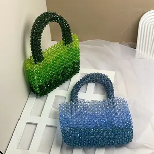 Detail of handcrafted acrylic beaded handbags in gradient blue and green crystal textures
