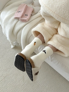Close-up of white plush thermal socks with cute carrot and rabbit embroidery