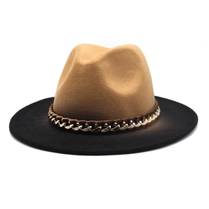 Detail of camel wool fedora hat featuring a chunky gold chain and black wide brim