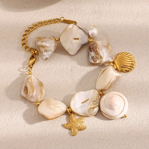 Détail d'un bracelet en perles de coquillage avec breloques étoile de mer et coquille dorée
