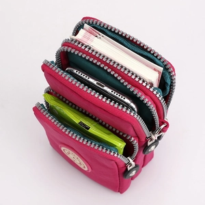 Three-layer nylon crossbody phone bag in rose red showing large storage space