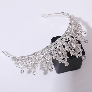 Detail of silver bridal crown featuring crystal leaf patterns and teardrop pendants
