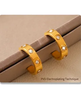 Macro view of C-shape gold earrings with PVD plating and sparkling cubic zirconia stones