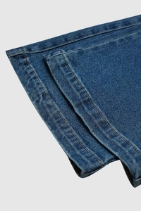 Macro shot of denim hem with high-quality orange double stitching on blue jeans