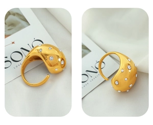 Detail of gold wide dome ring with micro-pave diamonds and white pearls on fabric