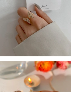 Close-up of golden butterfly open ring with sparkling zircon wings on a model's hand
