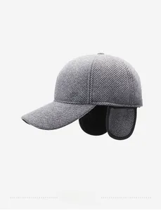 Detail view of winter baseball cap with ear flaps and sporty embroidery on thick grey fabric