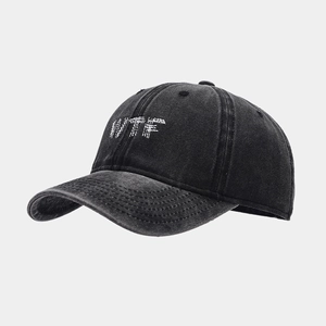 Détail de la broderie blanche WTF sur une casquette de baseball noire délavée vintage