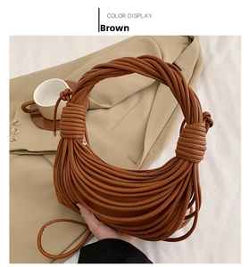 Detail of a brown woven knot hobo bag showing caramel leather texture and handle
